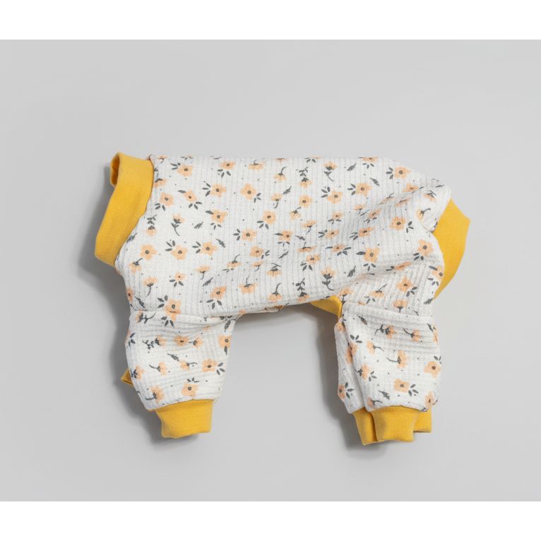 Floral-patterned dog romper with yellow cuffs and trim on a beige marble background