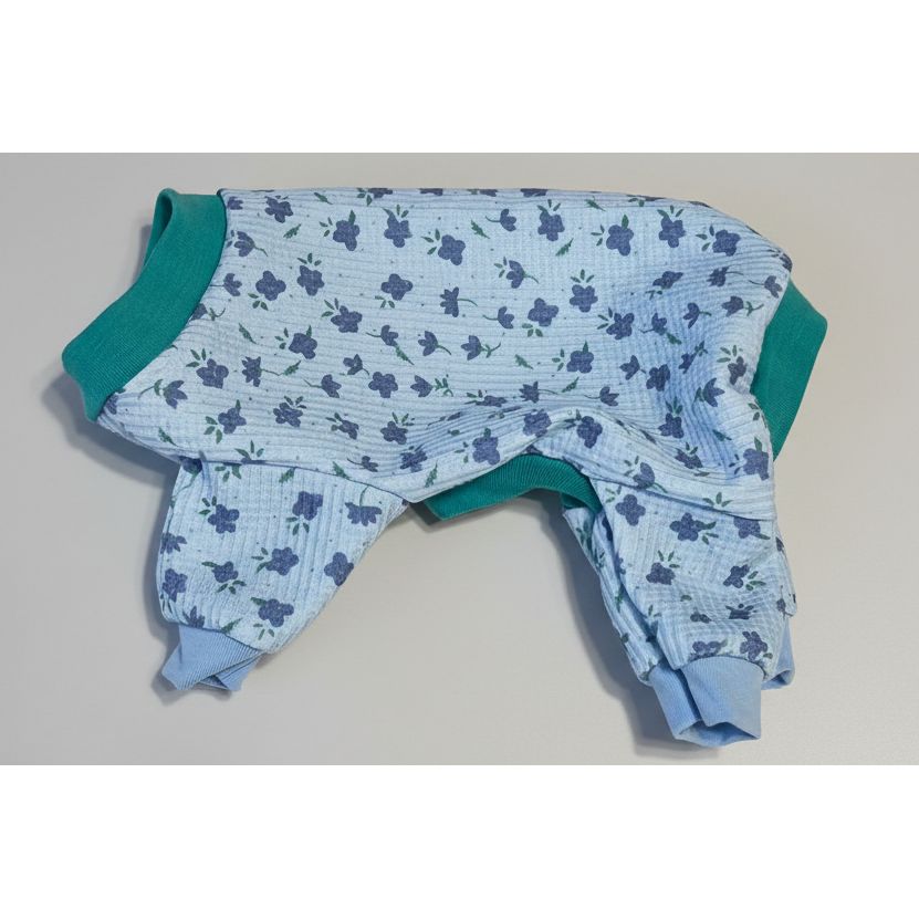 Blue floral-patterned dog pajamas on a beige surface