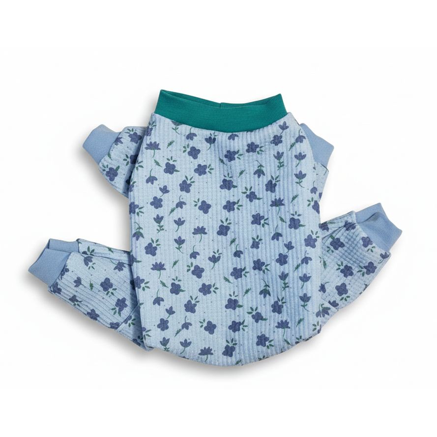 Floral-patterned dog pajama outfit on a beige marble surface