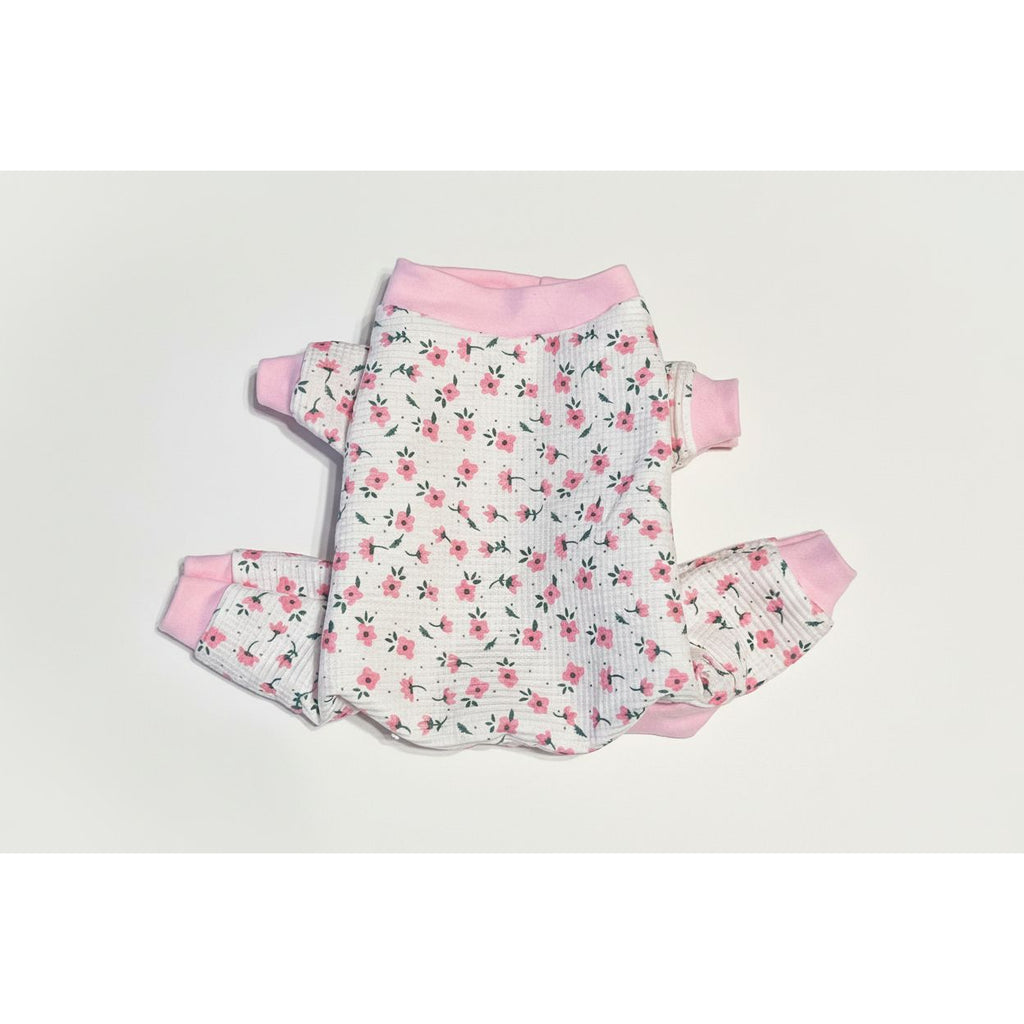 Floral dog pajamas with pink accents on a beige marble background