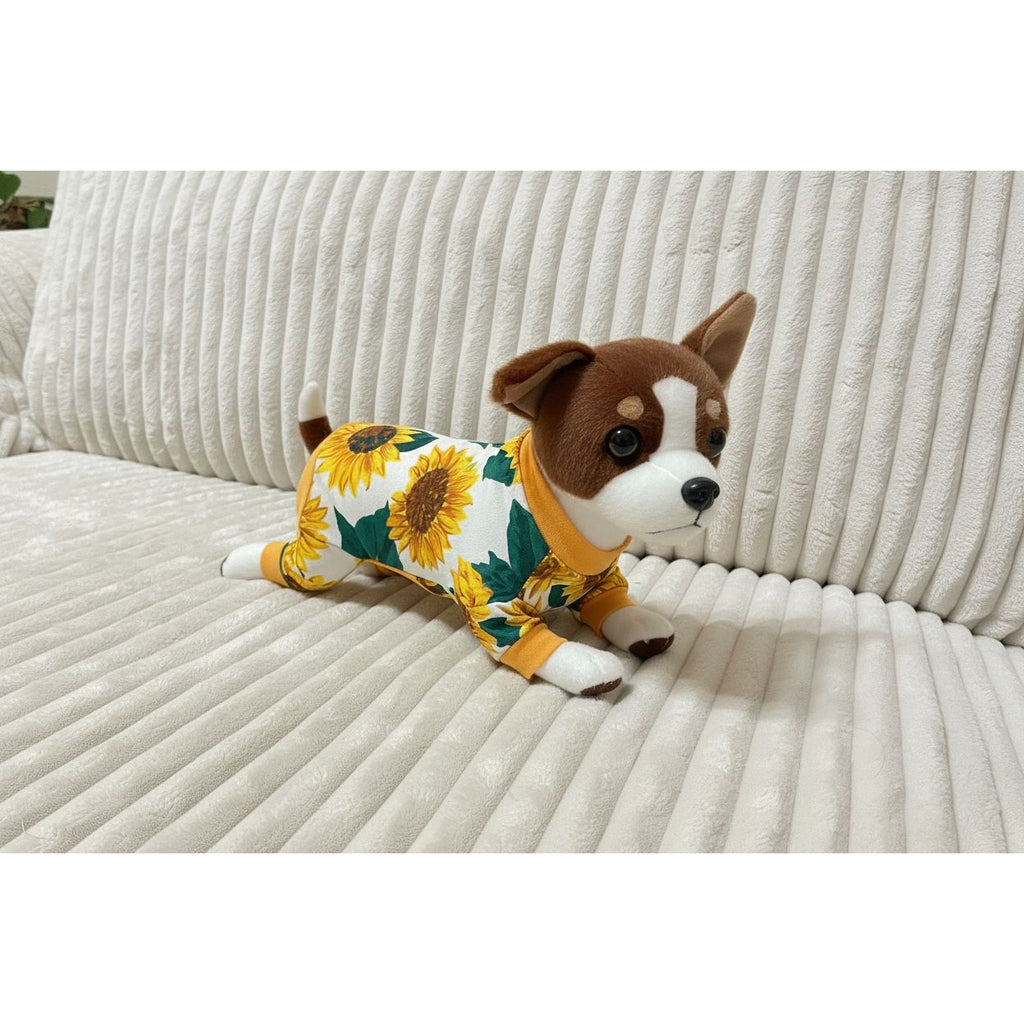 Small dog wearing a sunflower patterned outfit on a beige couch