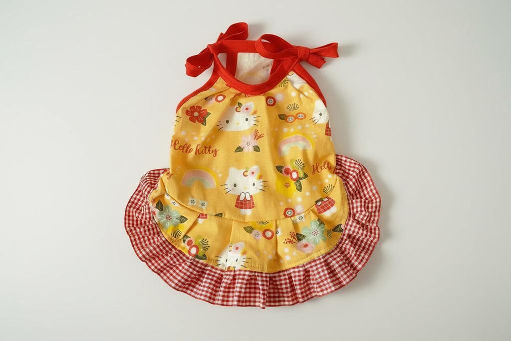 Yellow dress with red checkered skirt and Hello Kitty design on a white background