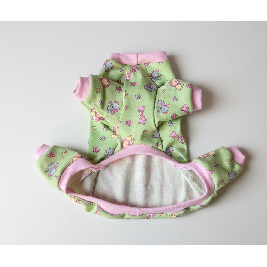 Green dog pajamas with pink trim on a pink surface