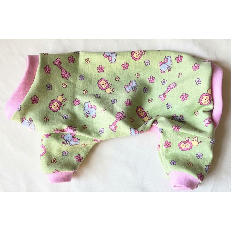Green fabric dog pajamas with cartoon patterns on a pink surface