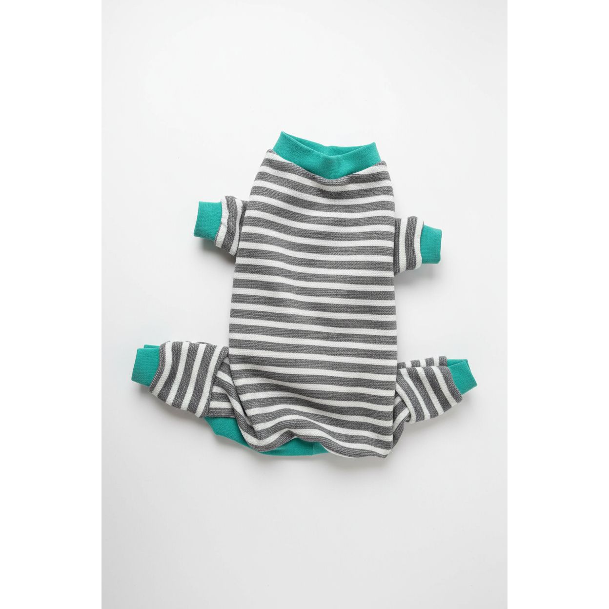 Striped dog pajamas with green cuffs and hem on a beige surface