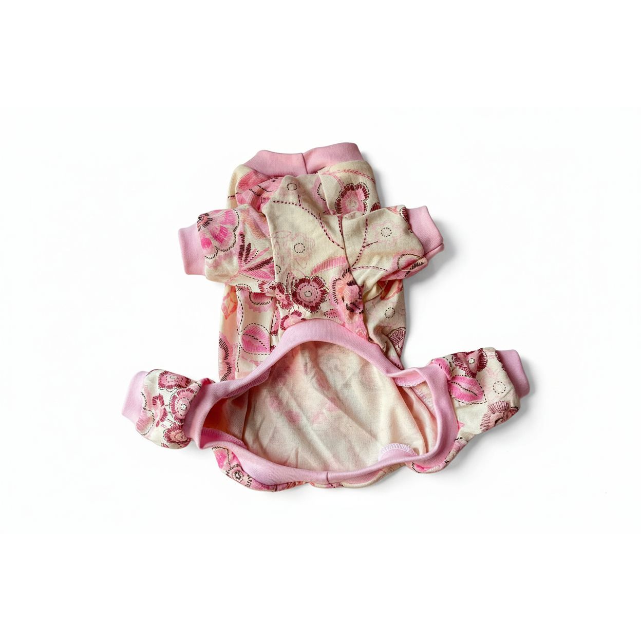 4 leg dog pajamas with pink and floral pattern on a beige surface