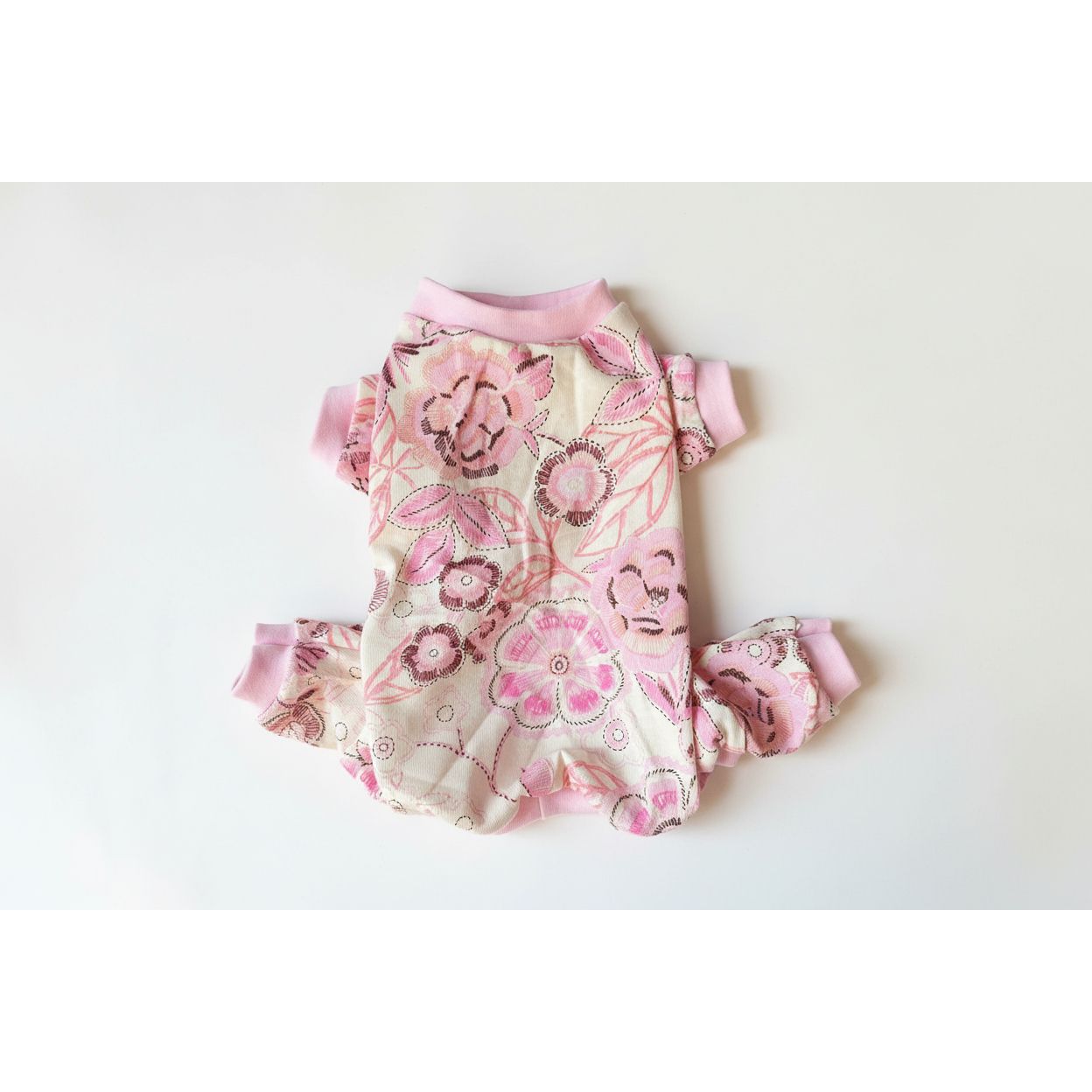 Floral patterned 4 leg dog pajamas with pink accents on a light background
