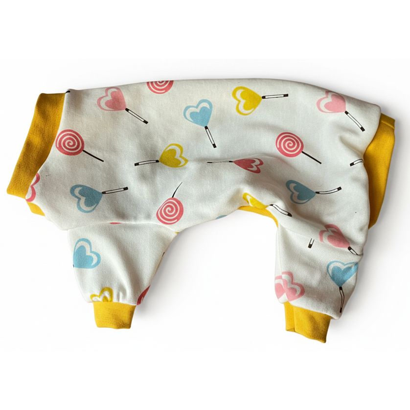 Baby 4 leg dog pajamas with a colorful heart and lollipop pattern on a pink surface