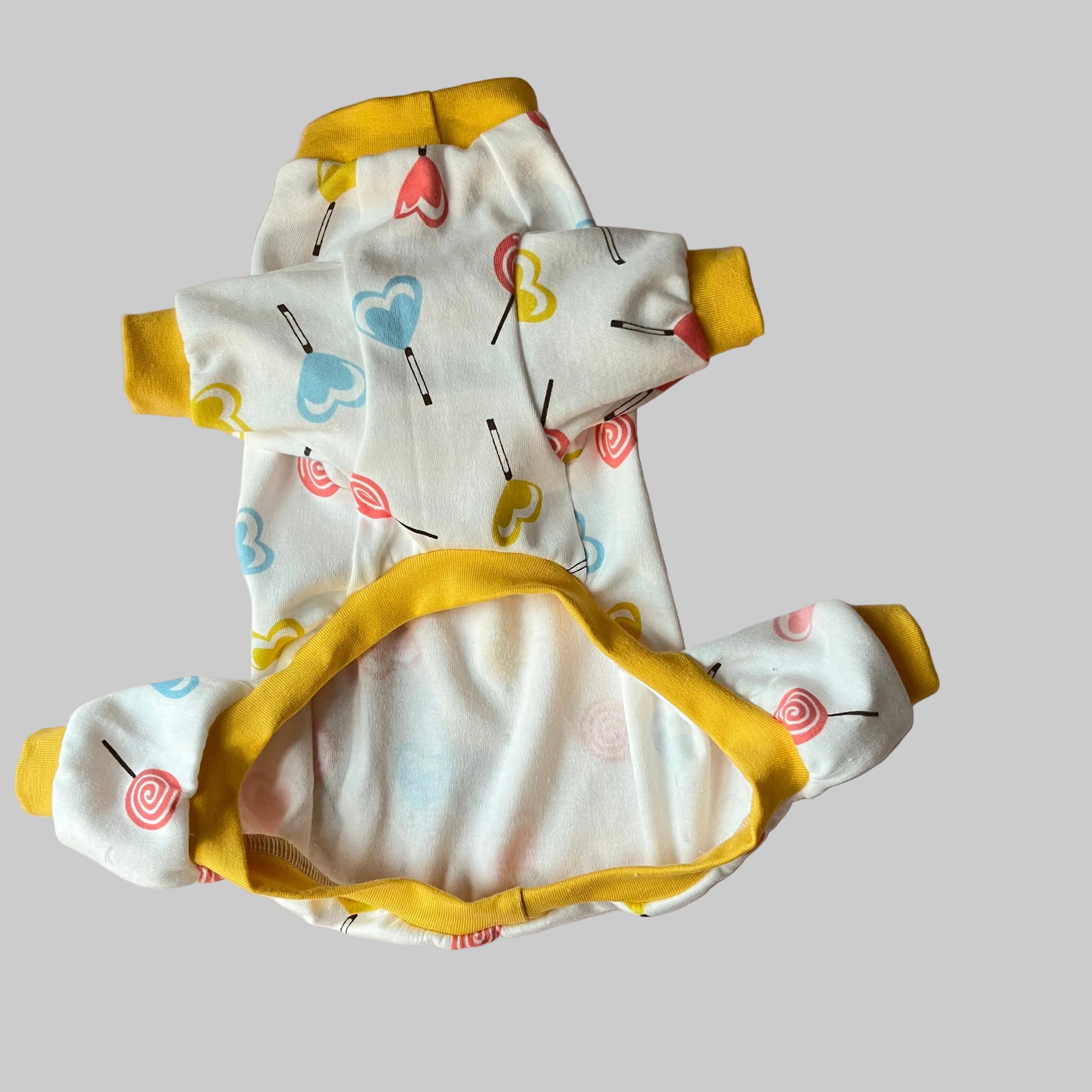 Baby romper with colorful patterns on a pink surface