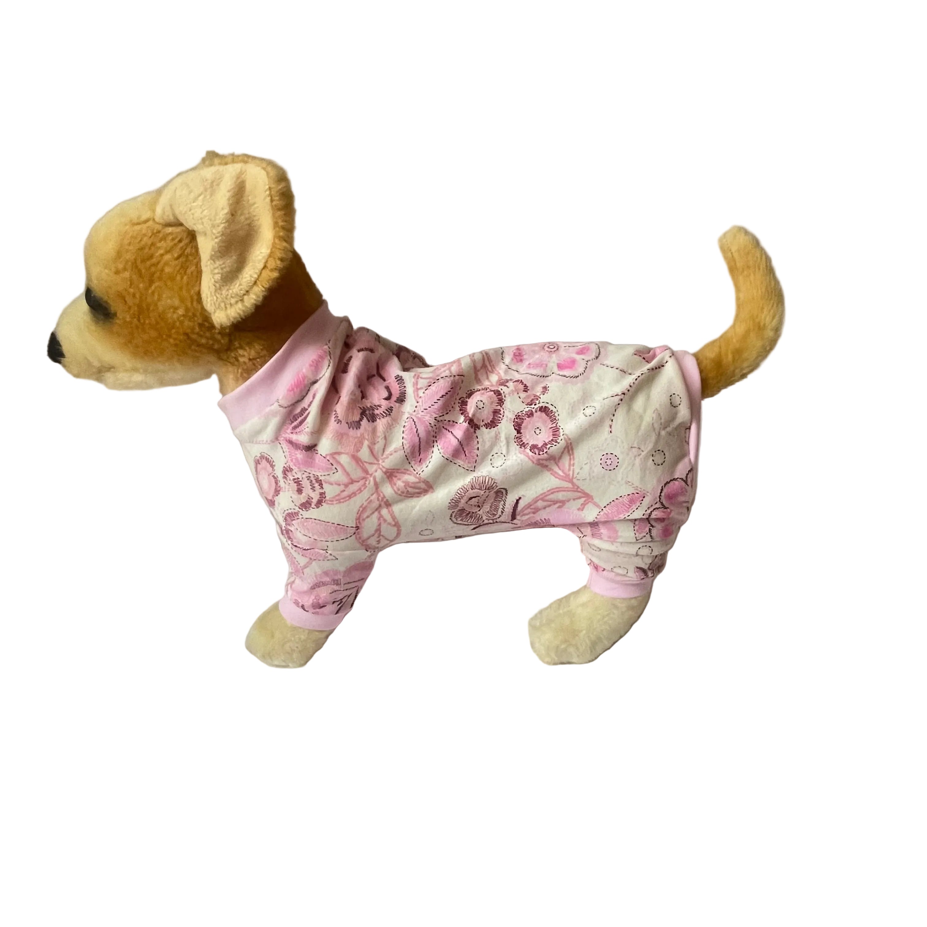 Stuffed dog toy wearing pink floral pajamas on a white background