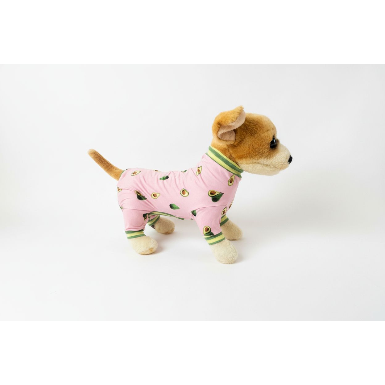 Dog wearing pink pajamas with avocado pattern on a white background