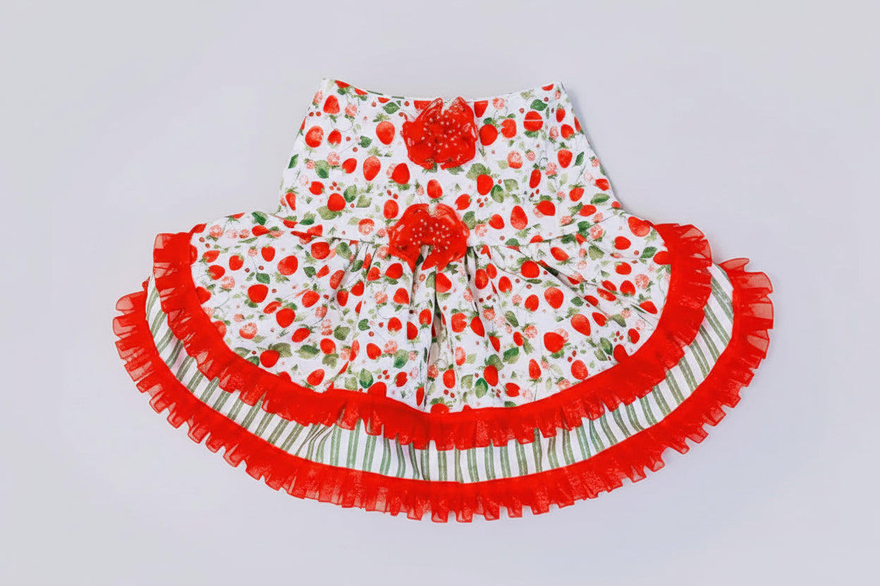 Children's dress with strawberry pattern on a light gray background